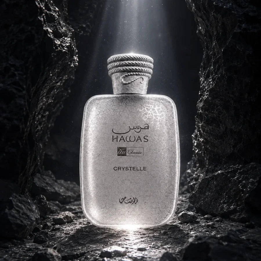 A frosted glass bottle labeled HAWAS Crystelle stands centered in a dark rocky cave-like setting with dramatic light rays shining down on it.